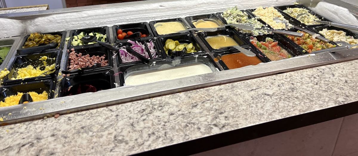 The salad bar with toppings and dressings